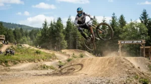 Launching off a timber tabletop feature in an English trail centre wearing the best MTB gloves for downhill.