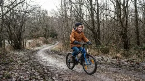 A child wearing junior full finger gloves for cold weather MTB on a family weekend cycle path